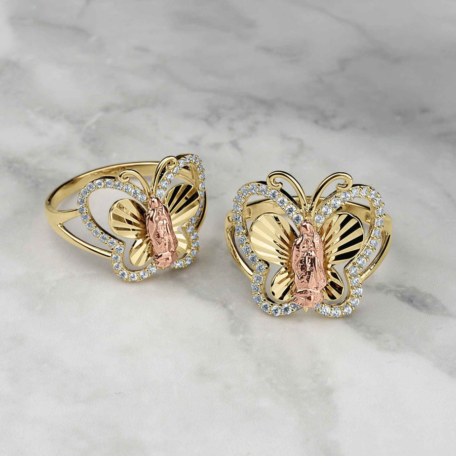 Two gold Virgin Mary Guadalupe butterfly rings with CZ stones on marble.