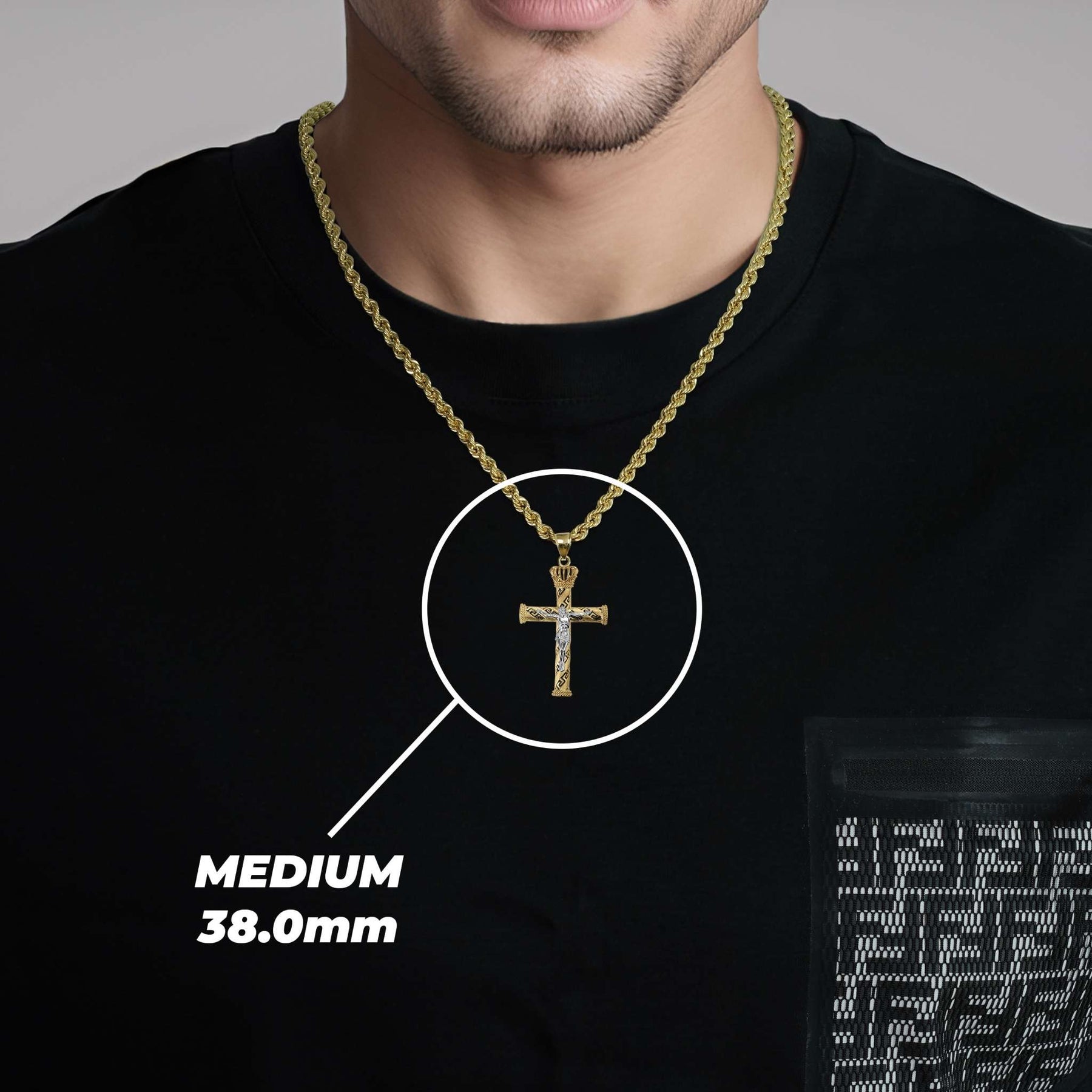 A man wearing a medium gold cross pendant labeled medium 38.0mm.
