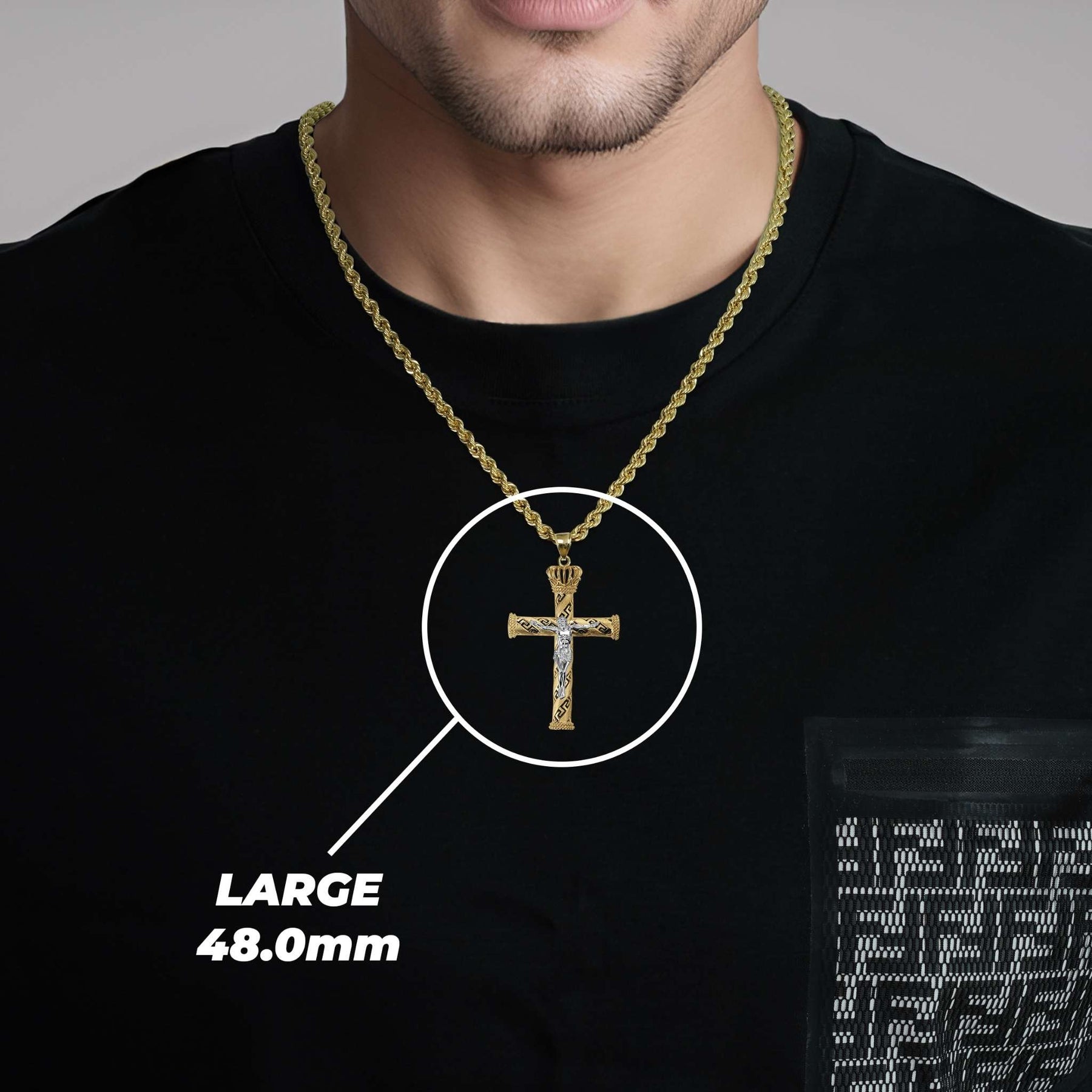A man wearing a large gold cross pendant labeled large 48.0mm.