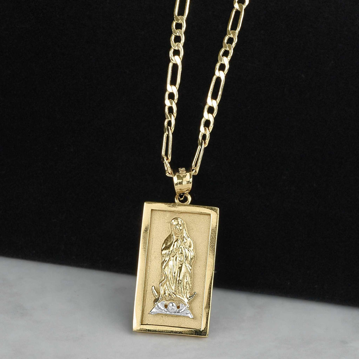 Rectangular two-tone gold Guadalupe pendant hanging on a gold chain against a dark background.