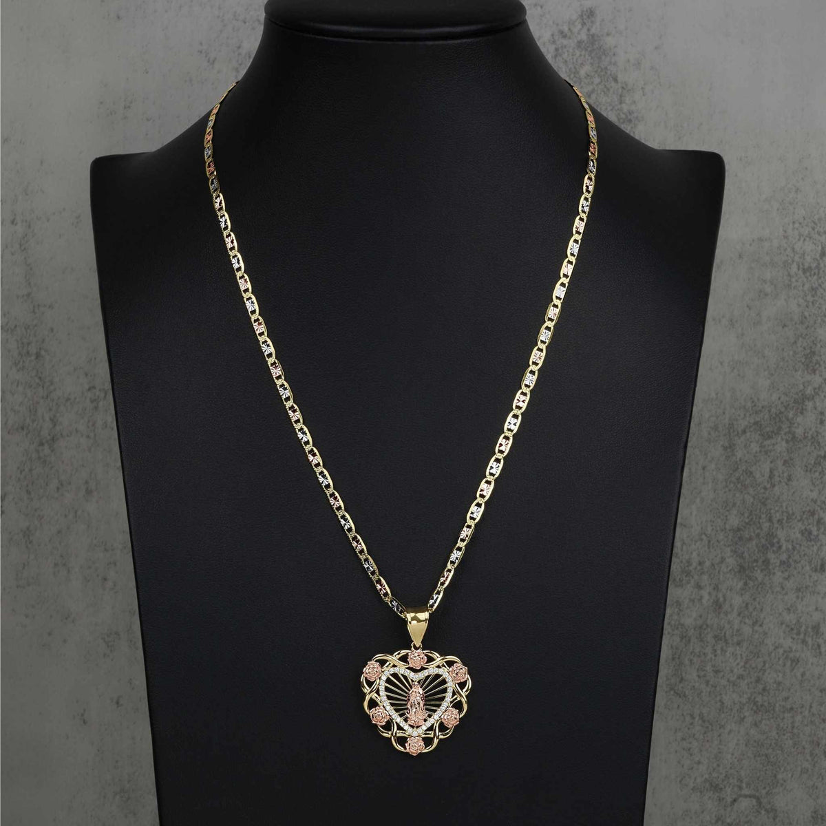 Tri-color gold Virgin Mary Guadalupe heart pendant necklace displayed on black bust.