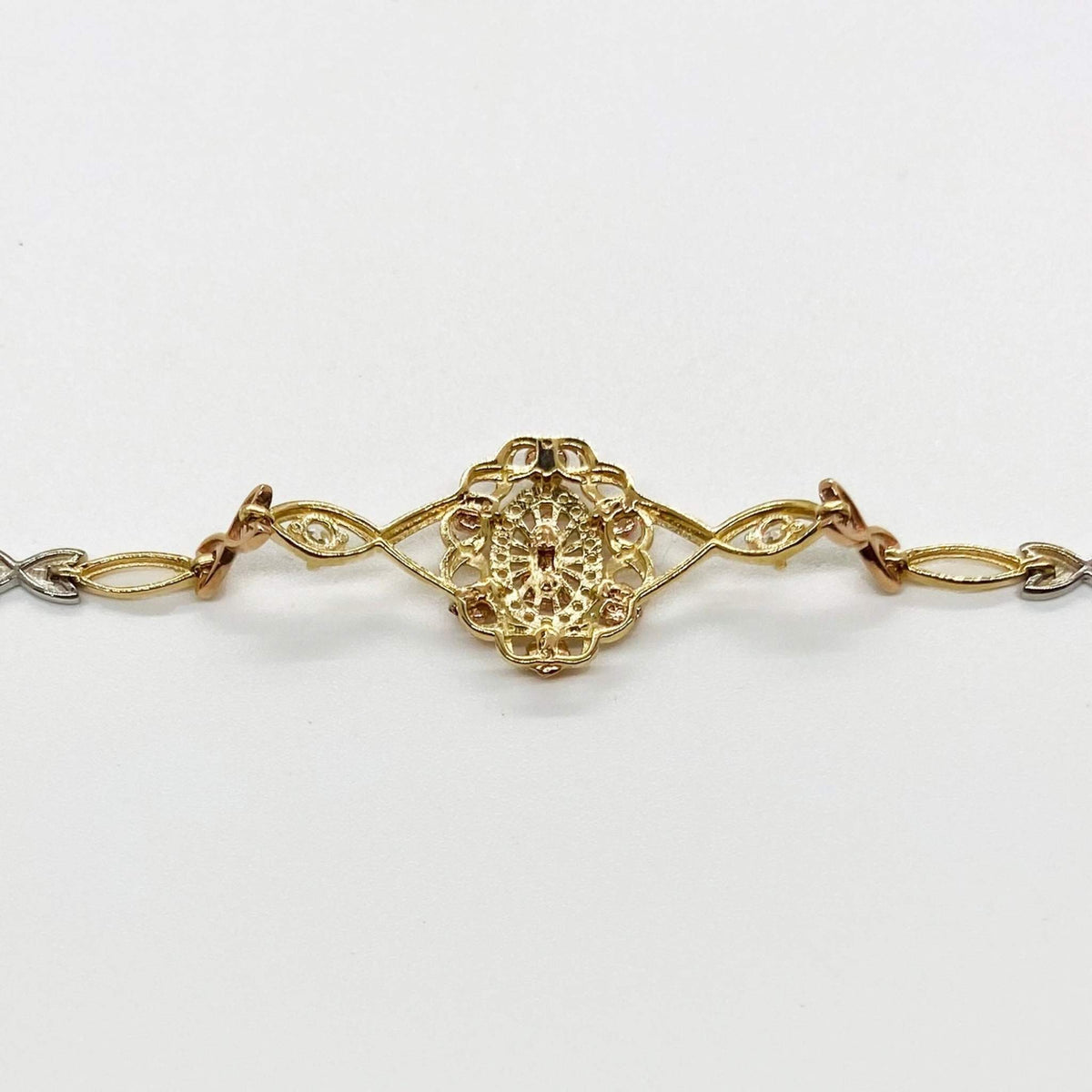 Back view of a tri-color gold Virgin Mary bracelet displaying detailed filigree craftsmanship