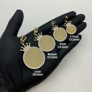 Four gold crown picture pendants in varying sizes displayed in a hand for scale comparison.