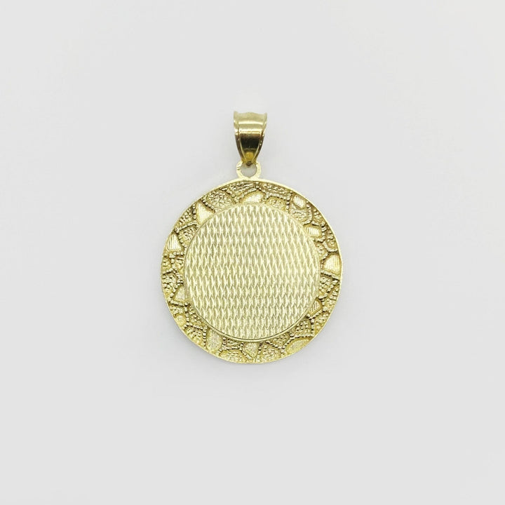 Round gold pendant with a textured crosshatch center and classic nugget-style border.