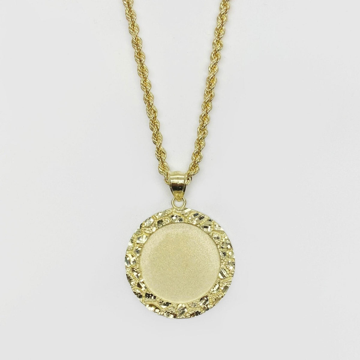 Round gold pendant necklace with a textured nugget border and smooth center for pictures