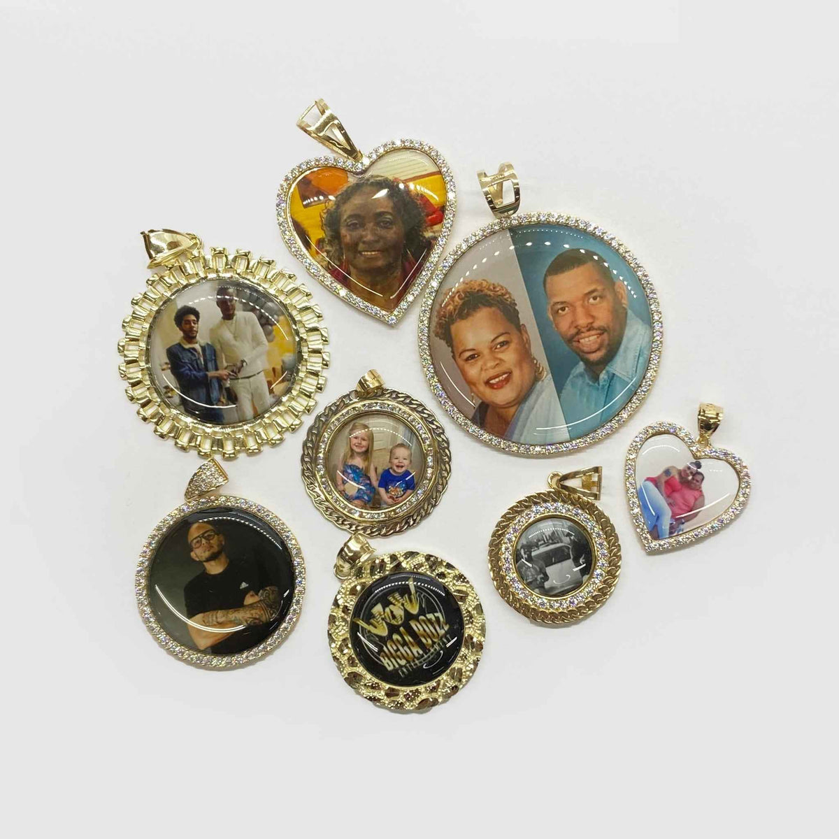 Assortment of gold picture pendants in round and heart shapes with custom photos.