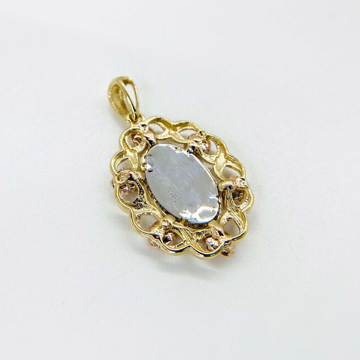 Back view of tri-color gold oval 'MOM' pendant showing flat white-gold center.