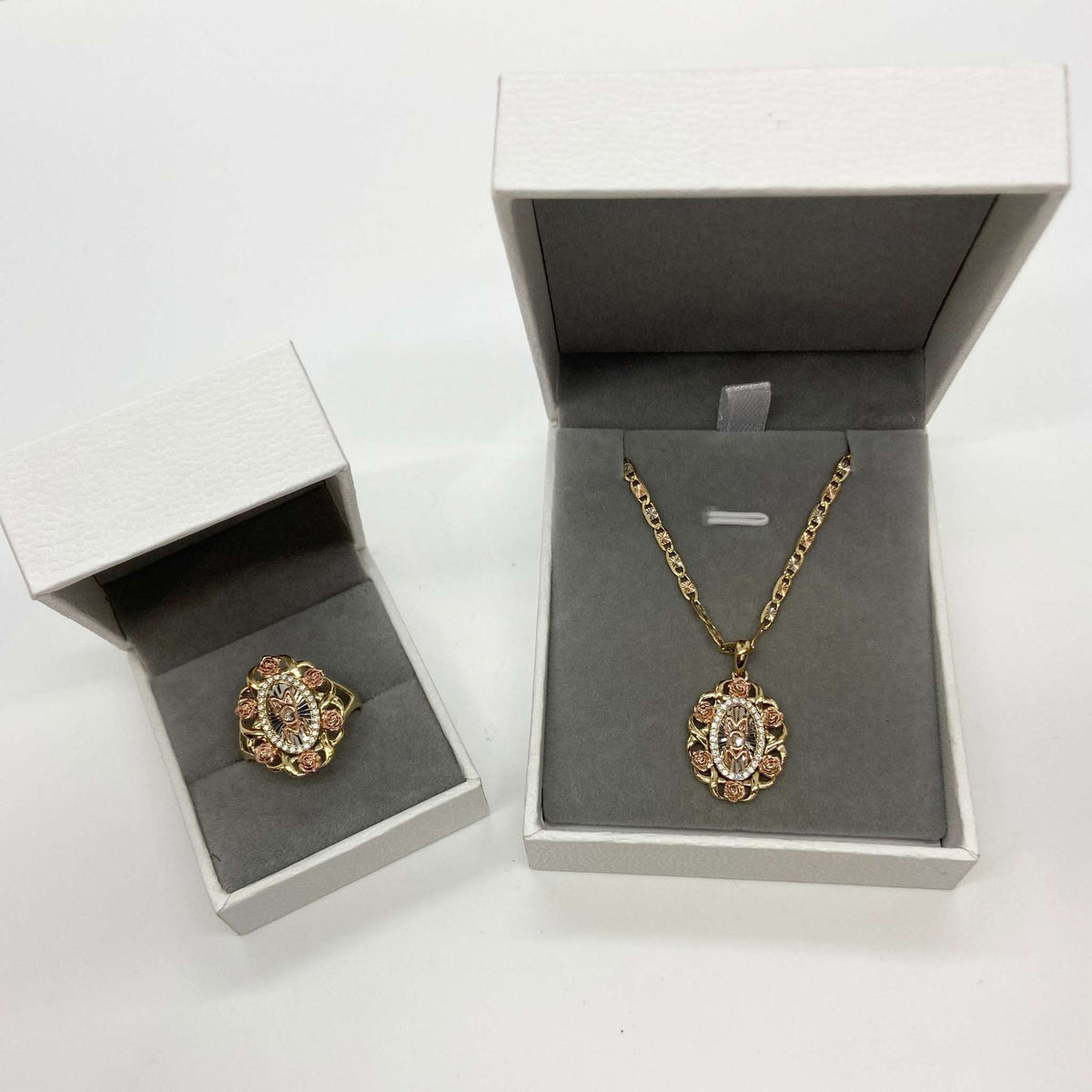 Tri-color gold 'MOM' pendant necklace and matching ring presented in white jewelry boxes.