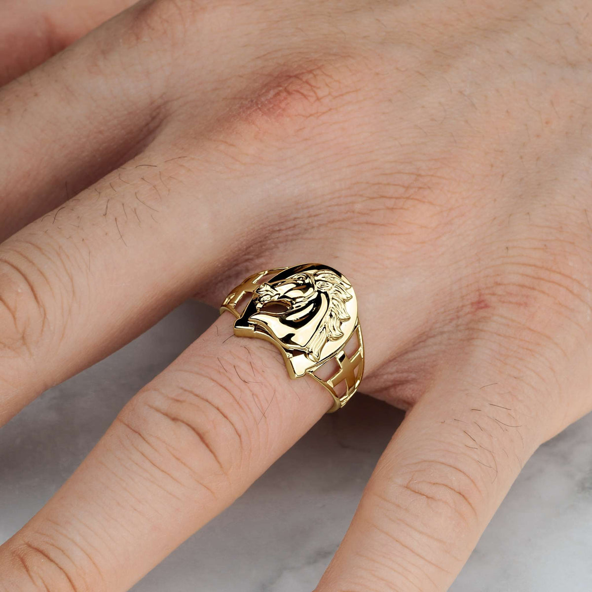 Yellow gold classic horse horseshoe ring lifestyle view on a hand.