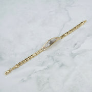 Tricolor gold Quinceañera leaf bracelet displayed diagonally on a white marble surface.