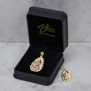 Two-tone gold Ovo Guadalupe pendant inside an open black Nolters box next to a smaller pendant.
