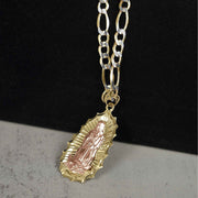 Two-tone 10k or 14k gold Virgin Mary Guadalupe oval pendant displayed on a gold Figaro chain.