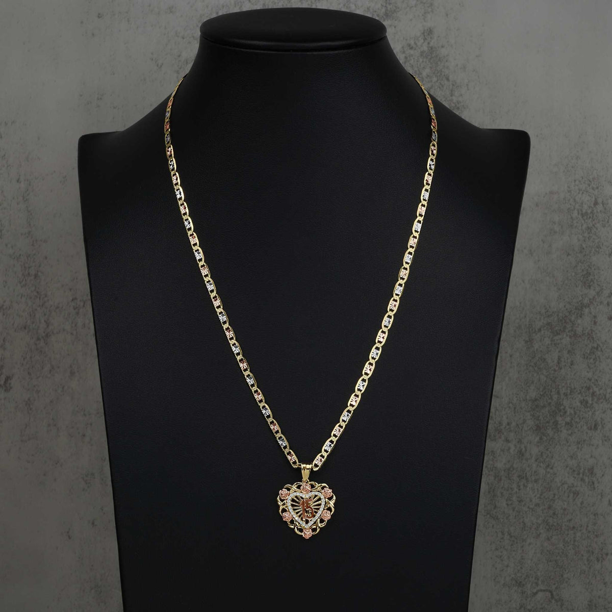 Two-tone Quinceanera heart pendant on a chain, displayed on a black jewelry bust.