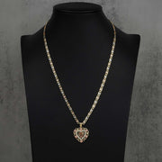 Two-tone gold 15th birthday heart pendant necklace presented on a dark display stand.