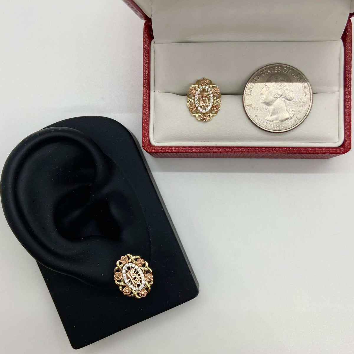 Tri-color gold Quinceanera stud earrings on a display stand with a quarter for scale.