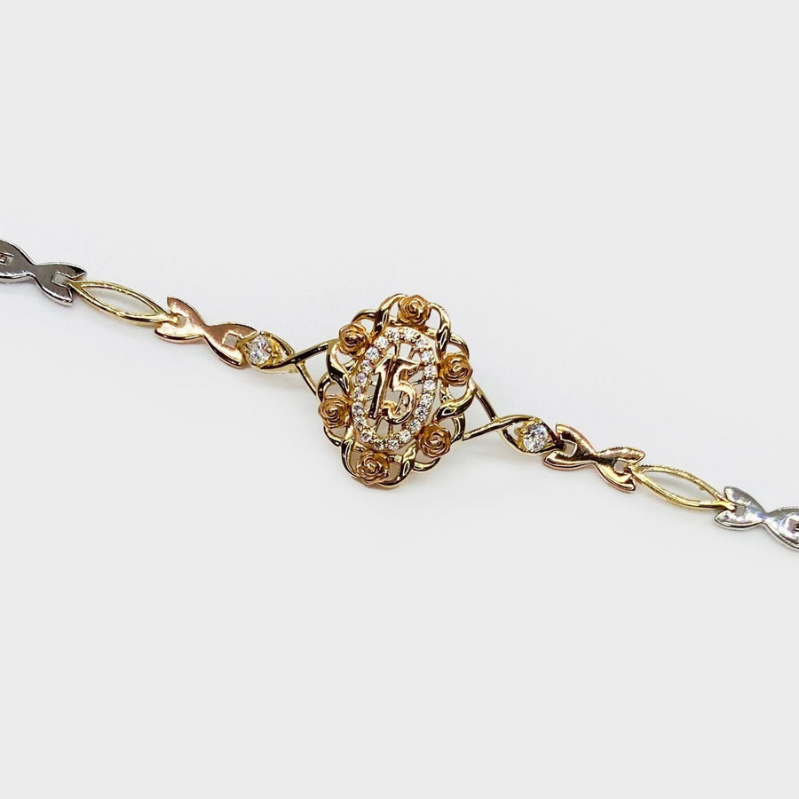 Tri-color gold Quinceañera 15 bloom rose charm bracelet on light background