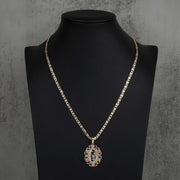 Gold chain necklace with an oval number 15 pendant on a black mannequin display.