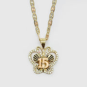Front view of two-tone gold Quinceañera butterfly pendant featuring CZ stones and 15 detail.