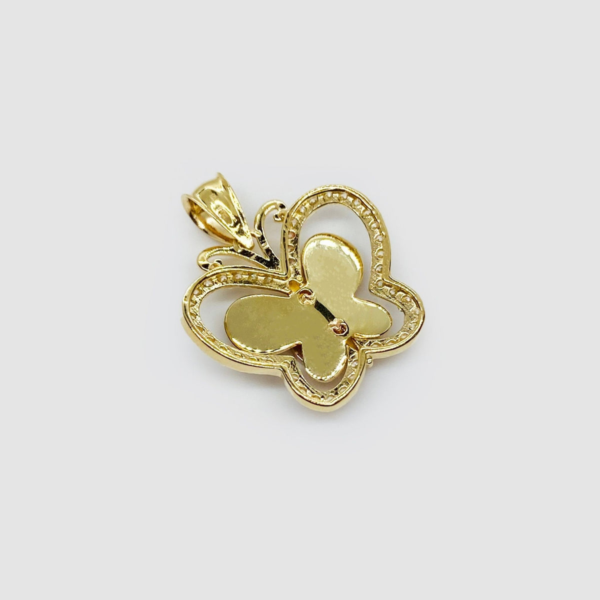 Back view of two-tone gold Quinceañera butterfly pendant showing hollow design.