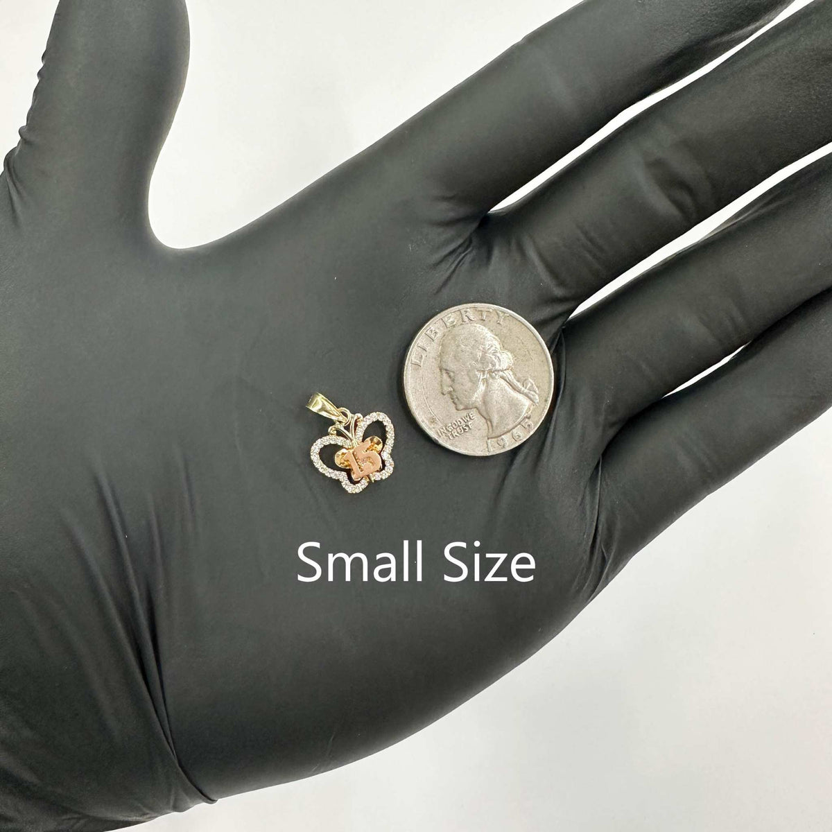Small size two-tone gold Quinceañera butterfly pendant next to US quarter for scale.