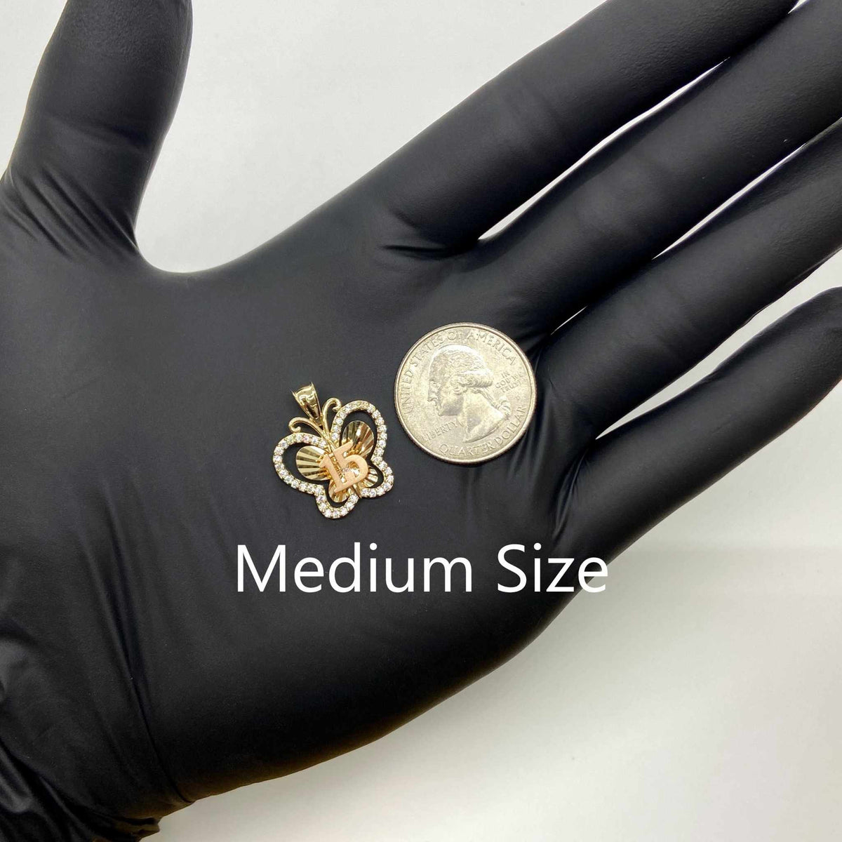 Medium size two-tone gold Quinceañera butterfly pendant next to US quarter for scale.