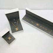 Three-piece gold Quinceañera 15 butterfly jewelry set with CZ accents packaged in white gift boxes.