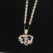 Gold chain necklace with a tri-color Quinceañera 15 heart pendant on a black background.