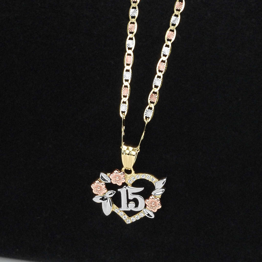 Gold chain necklace with a tri-color Quinceañera 15 heart pendant on a black background.