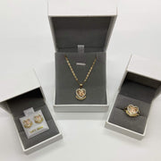Matching gold Quinceañera 15 jewelry set displaying necklace, ring, and earrings in boxes