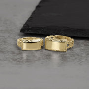 Two gold signet rings featuring engraved Greek key patterns and blank rectangular plates.