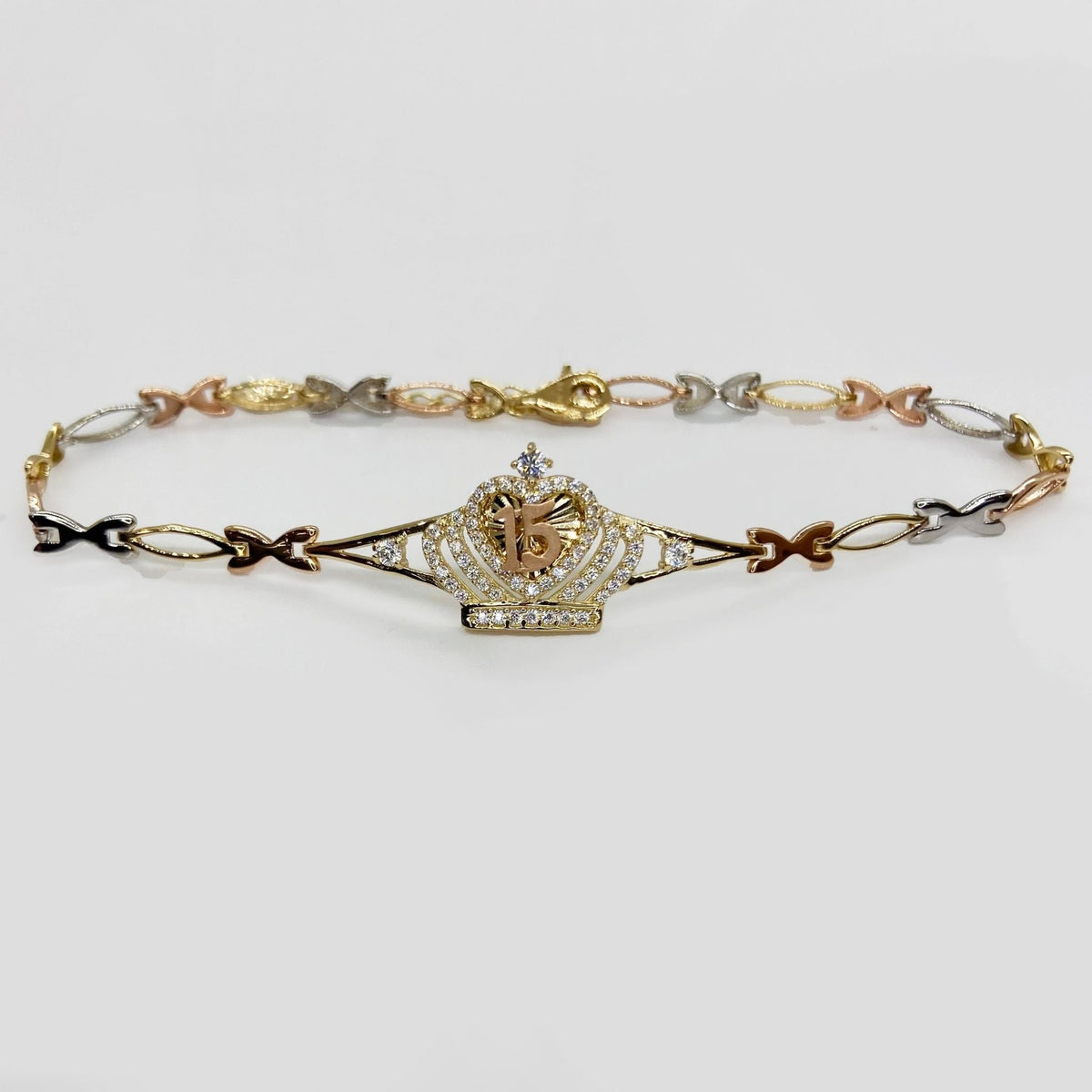 Gold Quinceañera crown bracelet with central crown charm and tri-color links.