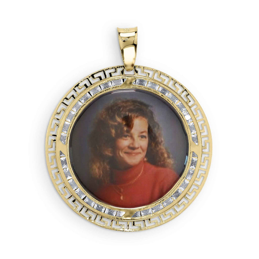 A woman's portrait in a round gold pendant featuring a Greek key pattern and clear stones.