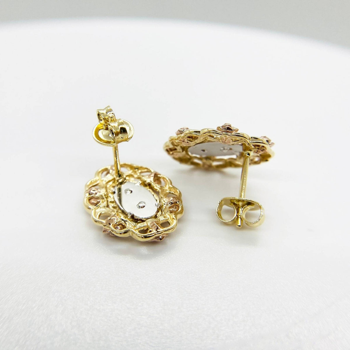 Reverse side of tri-color gold San Judas stud earrings with secure push-back closures.