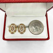ri-color gold San Judas oval earrings in a red box with a U.S. quarter.