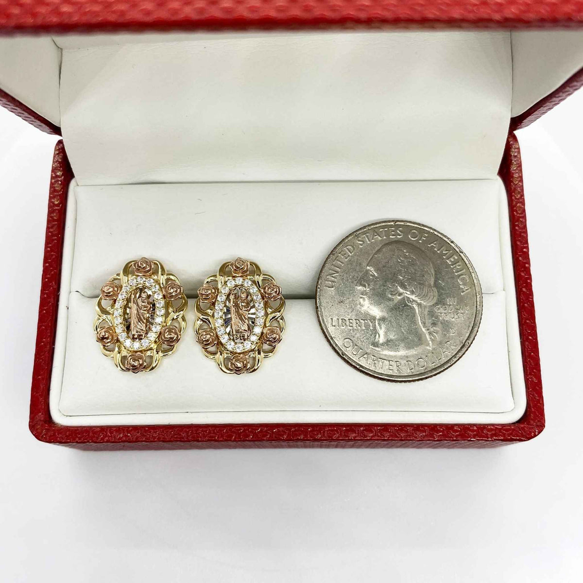 ri-color gold San Judas oval earrings in a red box with a U.S. quarter.