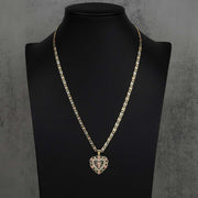 Two-tone gold San Judas heart pendant styled on a tricolor chain over a black mannequin bust.