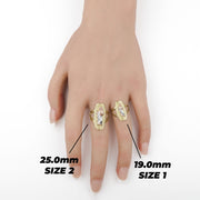 Hand wearing two gold San Judas rings showing Size 1 and Size 2 comparison.