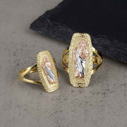 Two sizes of the gold tricolor San Judas rounded rectangle ring on a stone surface.