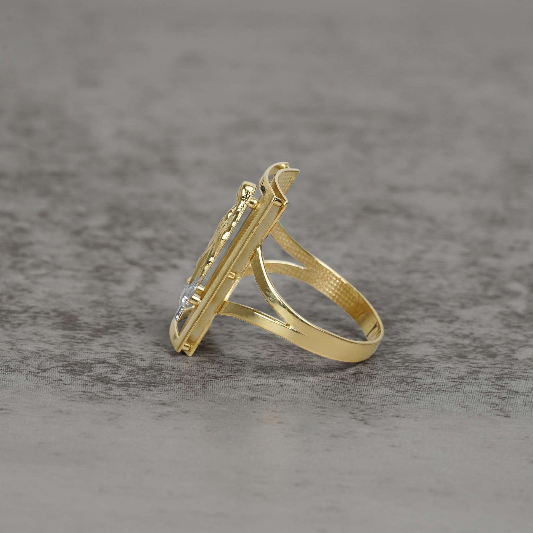 Side view of men's two-tone gold rectangular San Judas signet ring showing split-shank band.