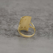 Hollow back view of men's two-tone gold rectangular San Judas signet ring on stone.
