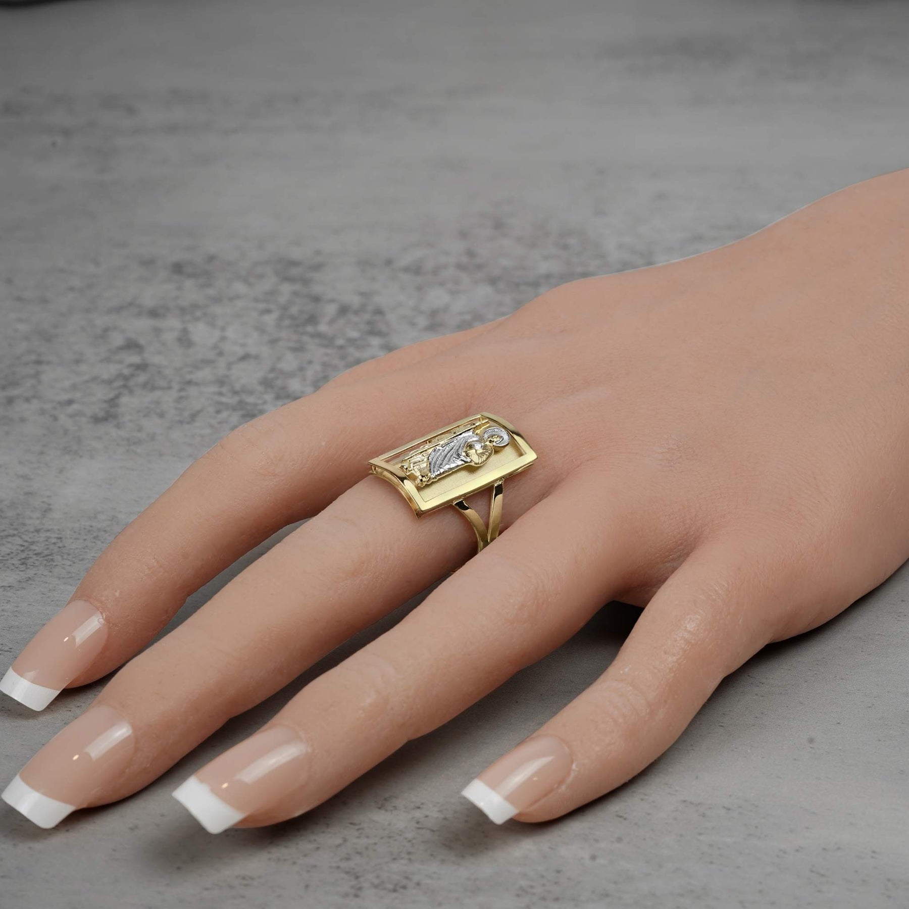 Model wearing a men's 10k two-tone gold rectangular San Judas signet ring on finger.