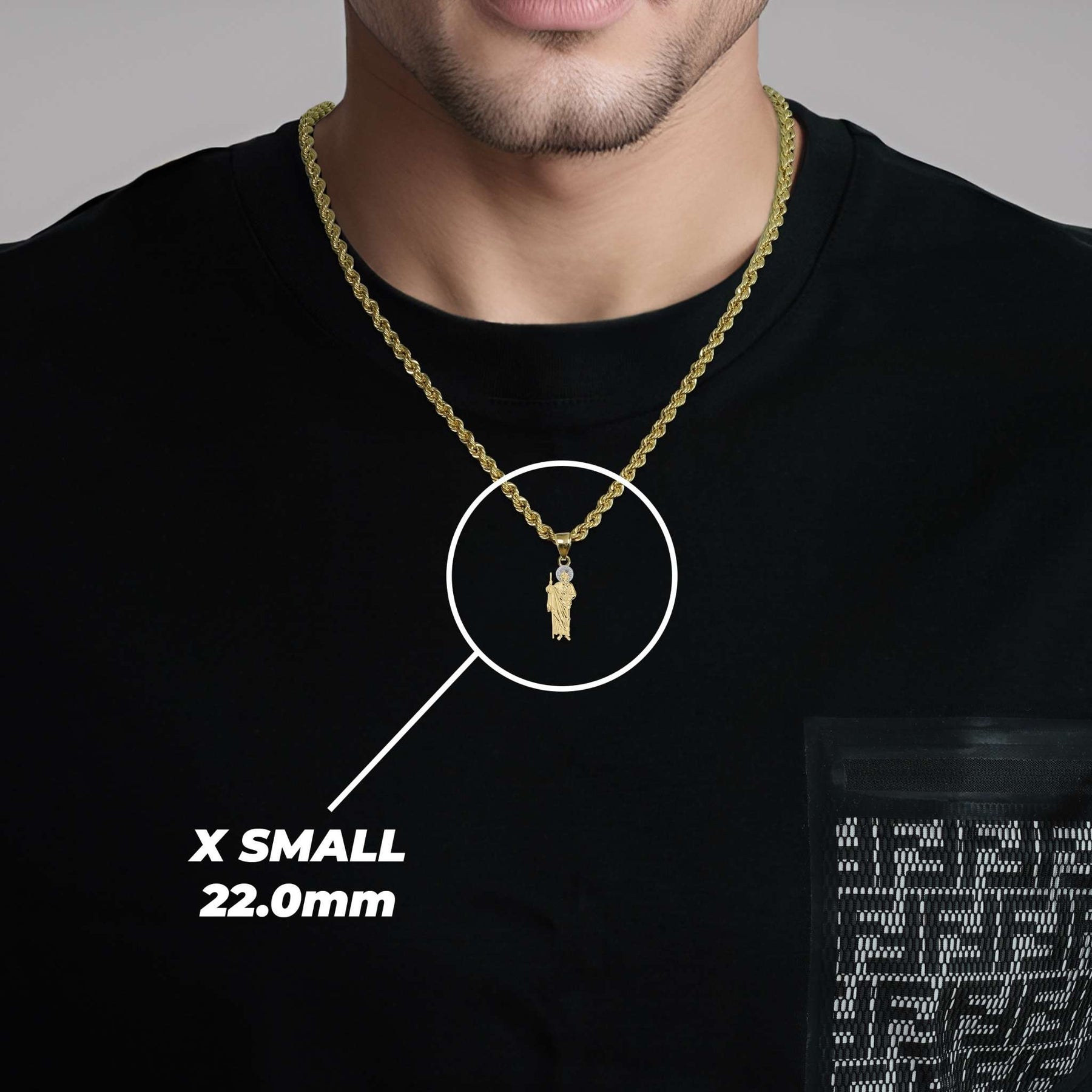 Model wearing a 22mm X Small two-tone gold Saint Jude pendant over a black shirt.