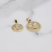 Gold Virgin Mary pendant necklace with a matching round medallion on display.