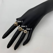 Black mannequin hand wearing three gold Sweet 16 Heart Ring with different designs.