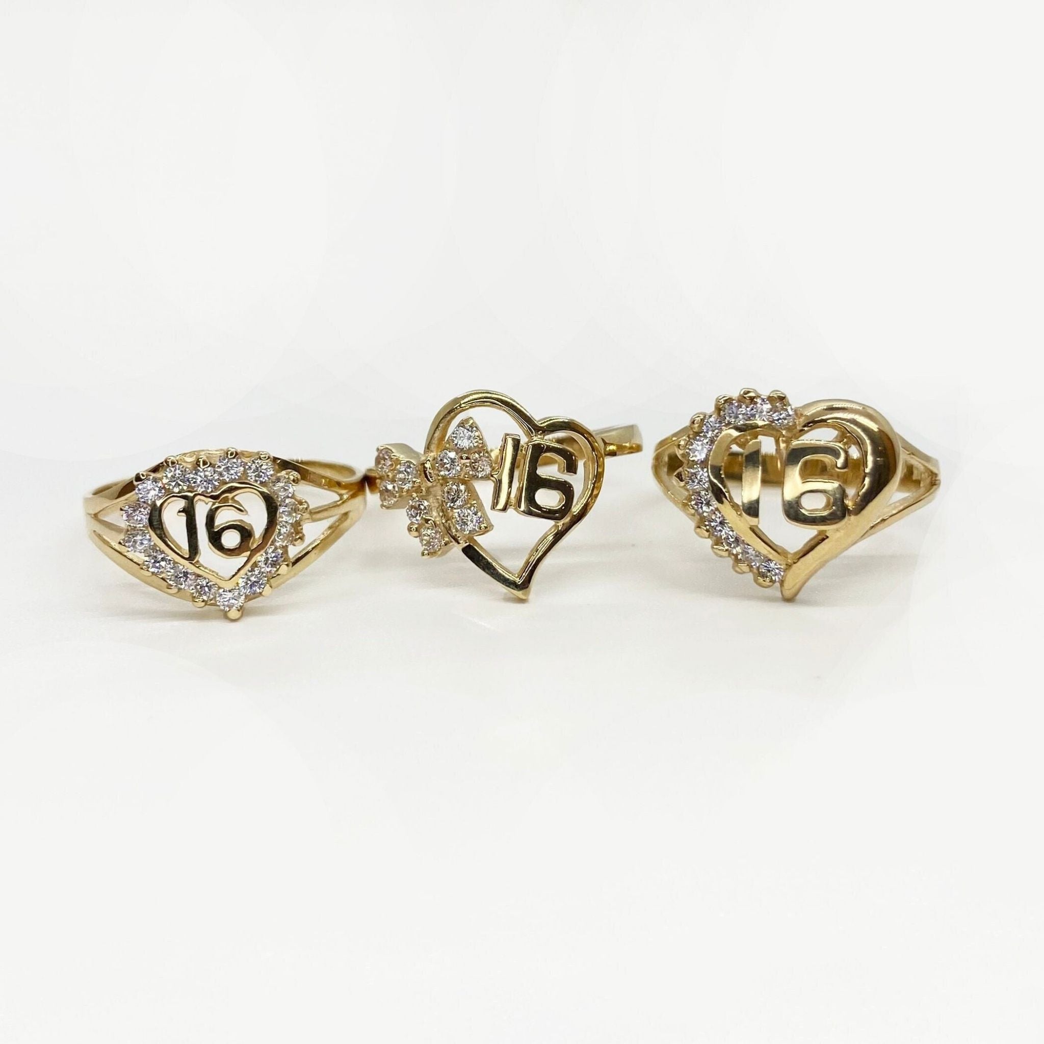 Three 10k - 14k gold heart shaped rings with number 16 designs.