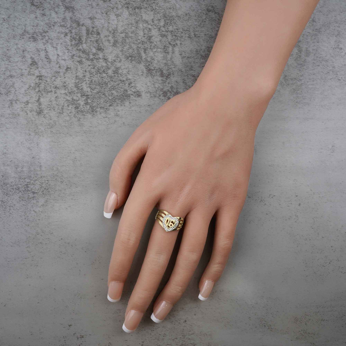 hand wearing a 10k - 14k heart shape gold ring with number 16 design.