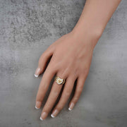hand wearing a 10k - 14k gold ring with a heart and number 15 design on a gray background