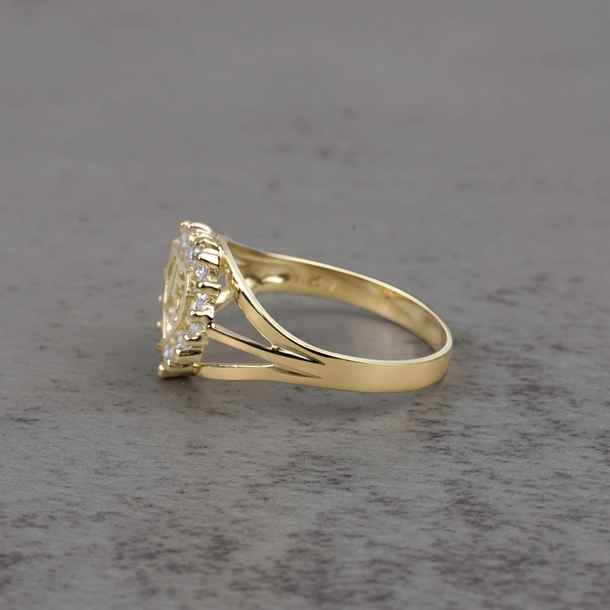 10k - 14k gold ring with a cubic zirconia side view on a gray surface