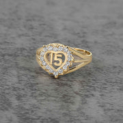 10k - 14k Gold ring with heart design and number 15 on a gray surface