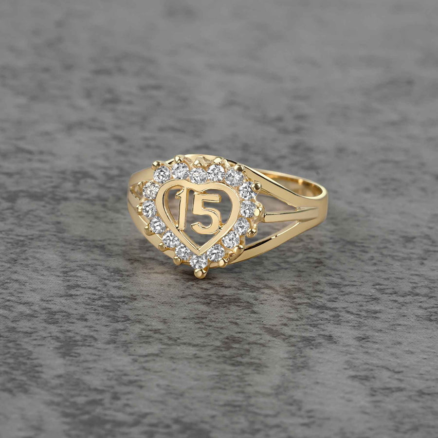 10k - 14k Gold ring with heart design and number 15 on a gray surface